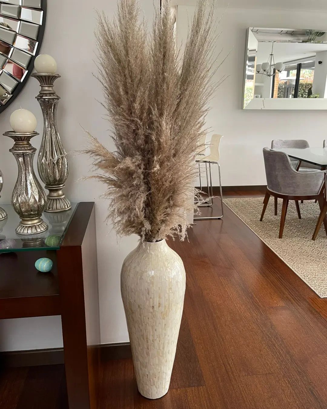 Large cream ceramic floor vase with fluffy pampas grass in a modern living room.