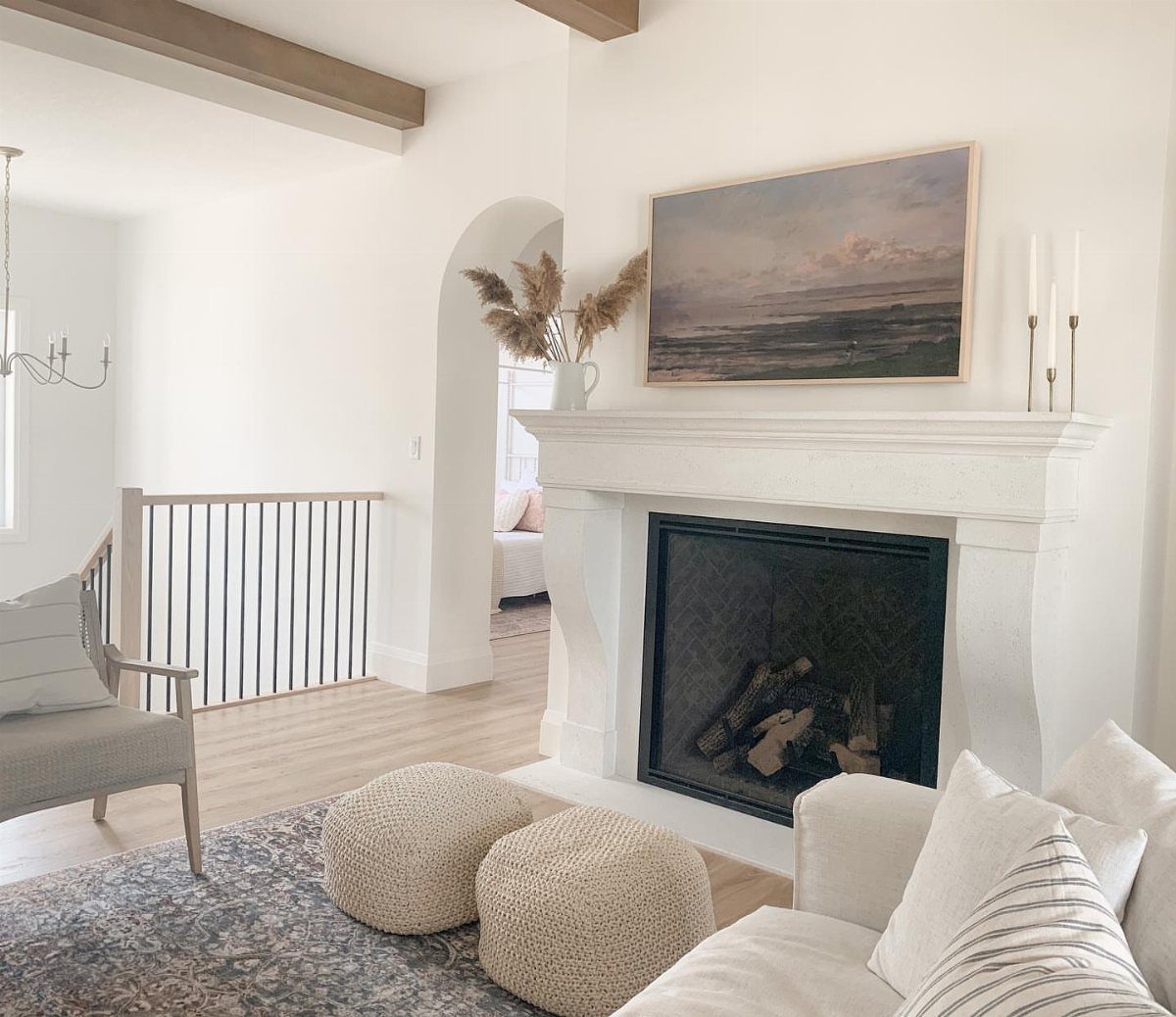 Pampas grass in a vase on a white fireplace mantel in a bright living room