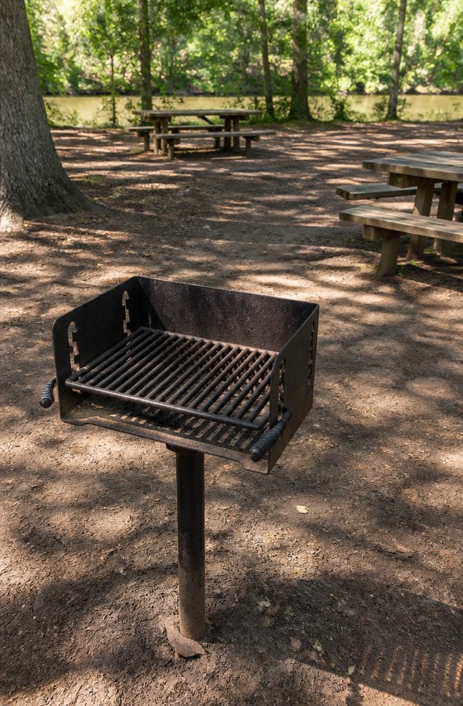 Rustic Outdoor Barbecue Grill Styles and Options for 2026 7 Standard park grill located in a picnic area with wooden tables.