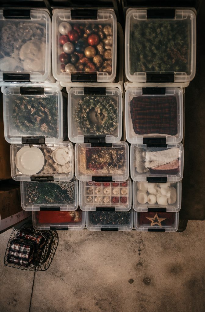 9 Small Basement Storage Ideas That Actually Fit Tight Spaces 9 Stacked storage bins with clear sides against a basement wall.