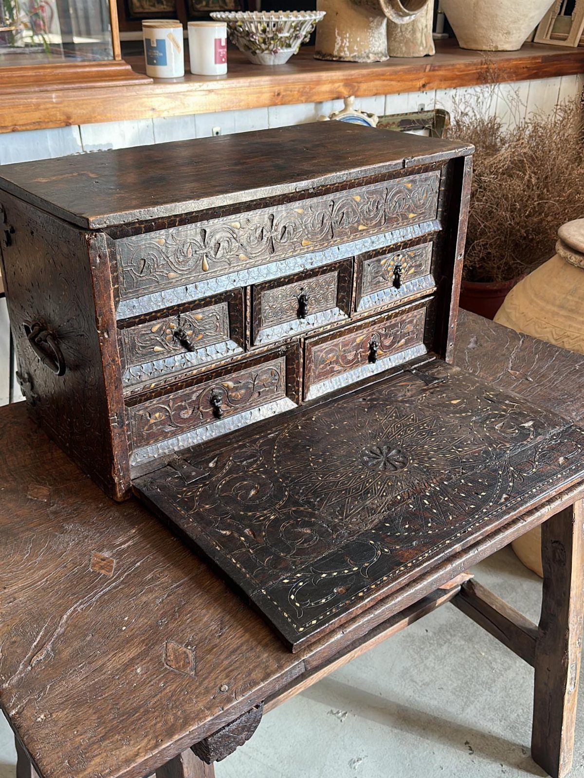13 Spanish Style Living Room Decor Ideas with Warm Character 5 Antique hand-carved wooden chest with ornate patterns resting on a rustic wooden table.