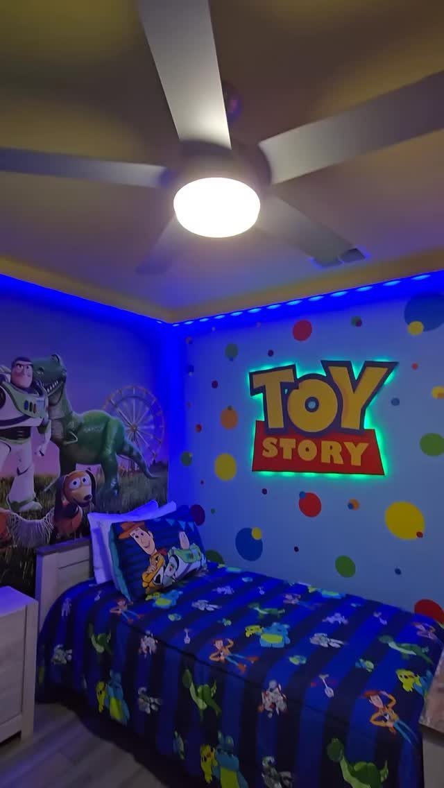 12 Toy Story Bedroom Ideas for Kids Who Love Woody and Buzz 12 Toy Story themed bedroom with blue walls, character mural, and glowing logo sign.
