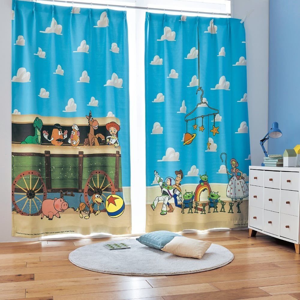 12 Toy Story Bedroom Ideas for Kids Who Love Woody and Buzz 2 Toy Story character curtains hanging in a bright child's bedroom with wooden floors.